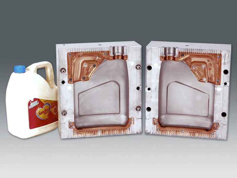 An open two-cavity blow mould beside the jerry can it produces, with Beryllium Copper inserts at the neck and pinch-off.